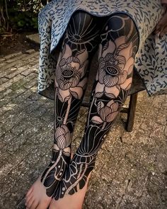 a woman's legs with black and white tattoos on them