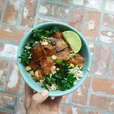 a person holding a blue bowl filled with food