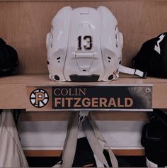 a hockey goalie helmet sitting on top of a wooden shelf next to other sports equipment