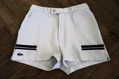 Beautiful Vintage Lacoste tennis shorts from the 1980s. White structured fabric with blue details. Zip fly, elasticated waistband, side pockets, side vents. Lacoste brand logo on the right bottom. Unlined. BRAND: Chemise Lacoste ERA: 1980s COLOUR: White, blue FABRIC: 100% polyester SIZE: Vintage size 40, fits best size S to M  - please check the measurements below for reference MEASUREMENTS: Single waist 36cm, stretches up to 38cm, total length 34cm CONDITION: Very good Vintage condition, minor Retro White Beach Shorts, Retro White Fitted Shorts, Blue Tennis Bottoms With Built-in Shorts, Retro White Shorts With Pockets, Vintage White Shorts, Vintage Lacoste, Luxury White Sporty Shorts, Tennis Shorts, Blue Fabric