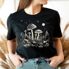 a woman wearing a black t - shirt with mushrooms on it