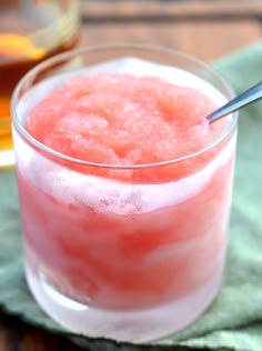 a glass filled with watermelon and ice on top of a green napkin next to a