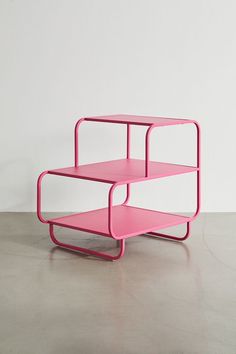 a pink shelf sitting on top of a cement floor