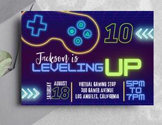 a video game birthday party ticket card with neon lights and a gaming controller on it