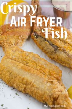 crispy air fryer fish on a plate with lemon wedges and dipping sauce