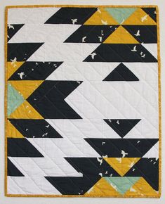 a black, white and yellow quilt with triangles on it