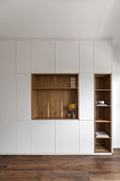 two bookshelves in the middle of a room with wooden flooring and white walls