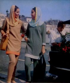 two women are walking down the street with their luggage in hand and one woman is holding a bag