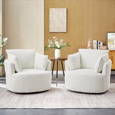 two white chairs sitting next to each other in a living room