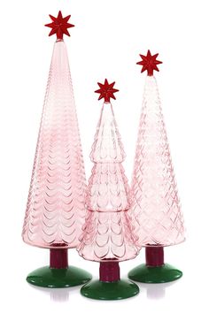 three glass christmas trees with red stars on top and green bases, set against a white background