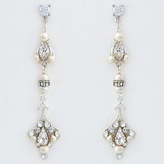 two pairs of earrings with pearls and diamonds on them, one is dangling from the side