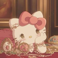 a hello kitty sitting on top of a bed next to a mirror and jewelry box