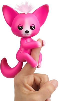 a hand holding a small pink toy animal