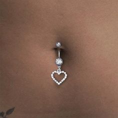 a woman's belly with a heart shaped navel bar attached to the side