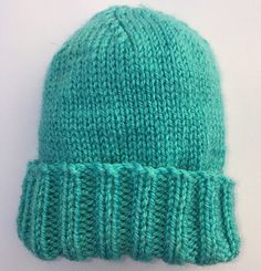 a green knitted hat on top of a white table