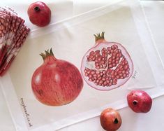 some pomegranates are sitting on a napkin next to two pieces of fruit