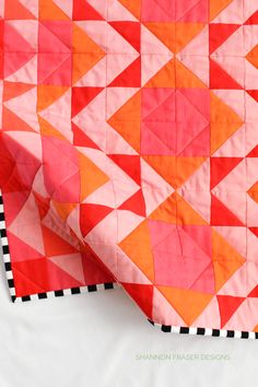 an orange and pink quilt on top of each other