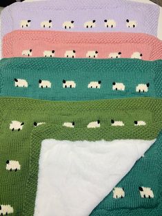 four knitted blankets with sheep on them