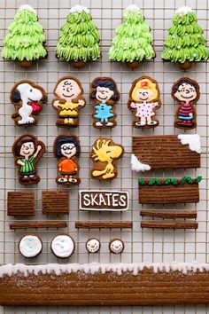 some cookies are arranged on a rack with trees and other items in the shape of people