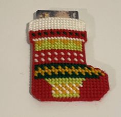 a knitted christmas stocking ornament hanging on a wall