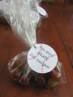 some grapes wrapped in plastic on a wooden table with a sign that says, u dida grape up tonight