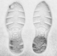 an image of someone's feet in the snow with their shoes covered by ice