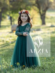 This stunning emerald green flower girl dress is truly a showstopper. The dress features a scallop V back design, adding a touch of elegance and sophistication to the overall look. The long sleeves are perfect for cooler weather or evening events, while the soft lace and tulle bottom adds a touch of whimsy and charm. The dress is fully lined for comfort and coverage, ensuring that your little flower girl will feel comfortable and confident all day long. The emerald green color is rich and vibrant, making it a perfect choice for fall or winter weddings. The dress is made from the softest materials, ensuring that your flower girl will feel like a princess as she walks down the aisle. Overall, this emerald green flower girl dress is a stunning choice for any special occasion. With its beautif Dark Green Flower Girl Dresses, Flower Girl Dresses Green, Winter Flower Girl Dress, Fall Flower Girl Dresses