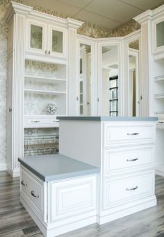 an empty kitchen with white cabinets and drawers