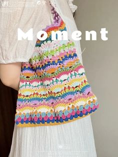 a crocheted bag is shown with the words moment written in white on it