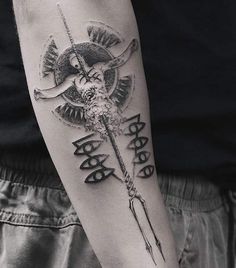 a person with a tattoo on their arm holding a stick and an arrow in the middle