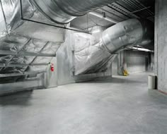 an empty industrial building with duct tape covering the walls and floor, as well as metal pipes