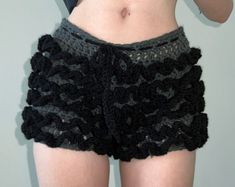 there is a woman wearing black shorts with crochet on the bottom