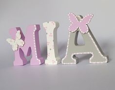 the letters are made out of wood and decorated with polka dot dots, butterfly accents