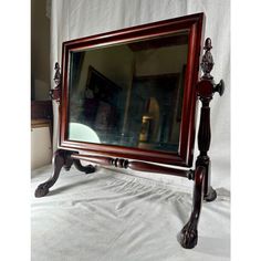 a large mirror sitting on top of a wooden stand