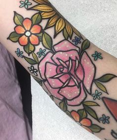 a woman's arm with a flower tattoo on it and an arrow in the center