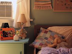 a bedroom with a bed, dresser and pictures on the wall