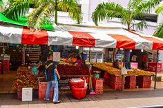 a man standing in front of a fruit stand