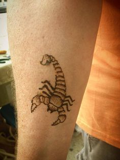 a man with a tattoo on his arm that has a scorpion drawn on the side