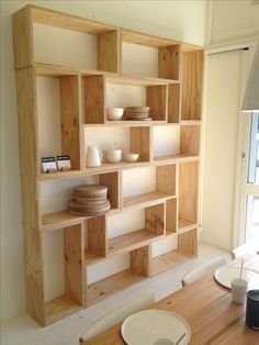 a wooden shelf with bowls and plates on it