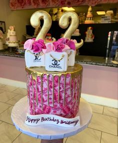 a birthday cake decorated with pink roses and gold numbers