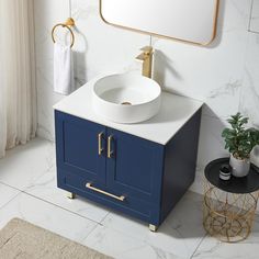 a white sink sitting on top of a blue cabinet next to a mirror and potted plant