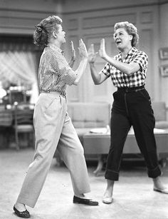 two women are dancing together in an old black and white photo, one is holding her hands out to the other