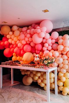 an instagram photo with balloons on the wall and table in front of it,