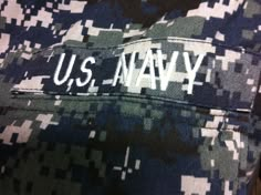 the u s navy logo is embroidered on an army camo uniform, which has been worn by several people