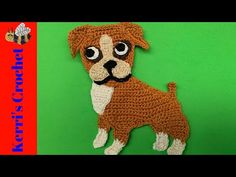 a crocheted brown and white dog on a green background