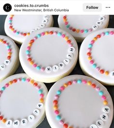 decorated cookies are arranged in the shape of circles with letters and numbers on them, along with name tags