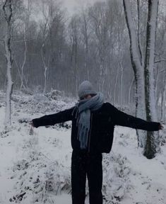 a person standing in the snow with their arms out and one hand outstretched to the side