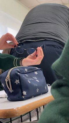 a person sitting at a table with some bags