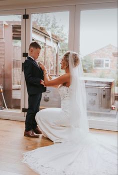 the bride and groom are getting ready for their wedding ceremony in front of an open window