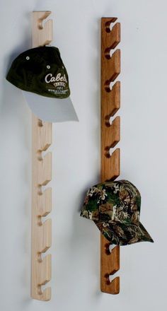 two hats are hanging on the wall next to a coat rack and hat rack that is made out of wood